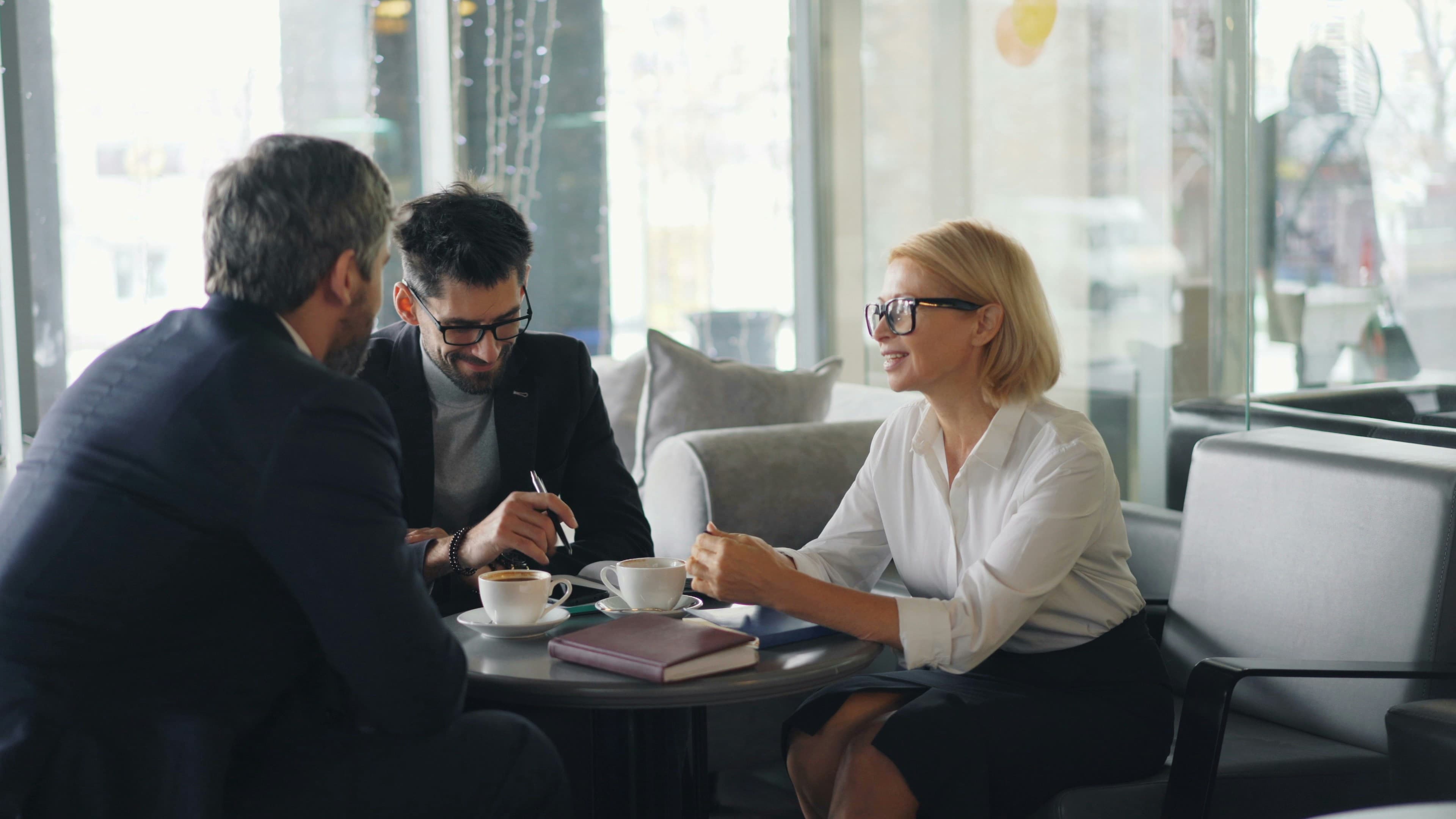 Abogada conversando con dos clientes en una reunión cercana y tranquila
